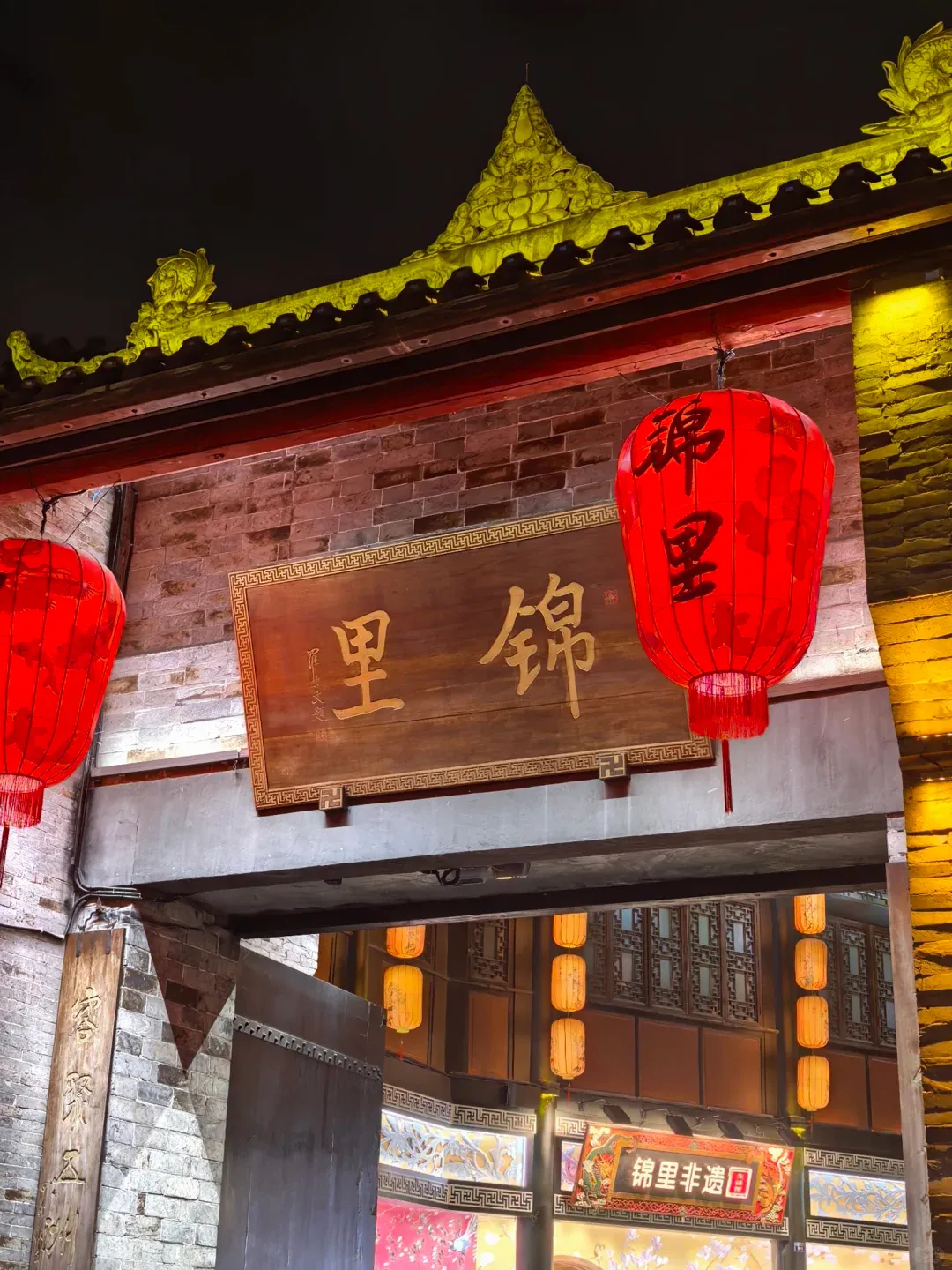 Red lanterns glowing above Jinli Ancient Street at dusk, traditional Sichuan architecture with cobblestone lanes